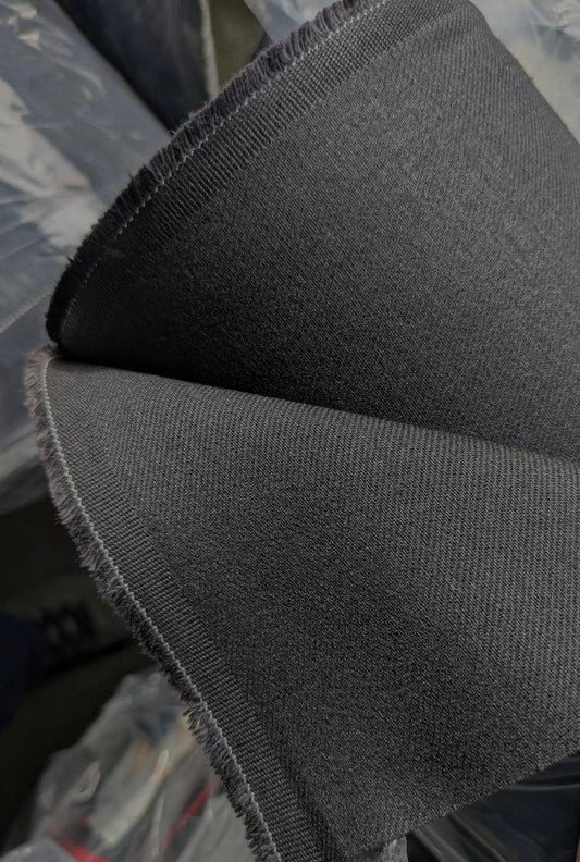 Close-up of Okayama Denim | 13.3oz double-width, double-sided black denim fabric showcasing its beautiful twill texture.