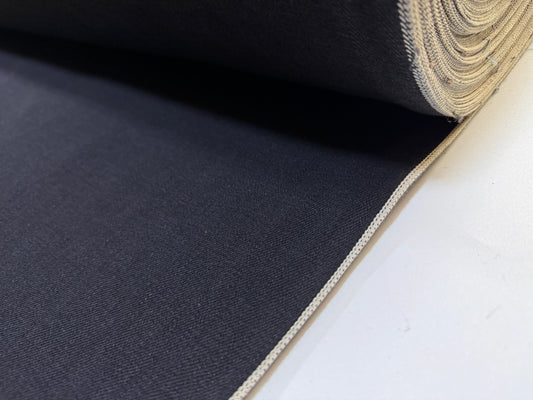 Okayama Denim | 12.5oz double-sided black selvage fabric rolled up showcasing smooth texture.