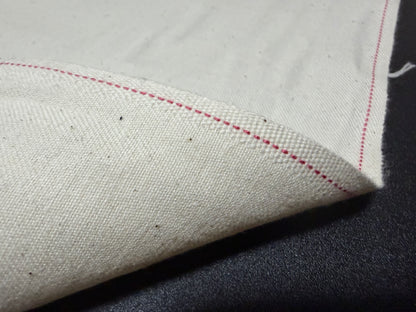 Okayama Denim cotton slake fabric showcasing unbleached color and red stitching details.