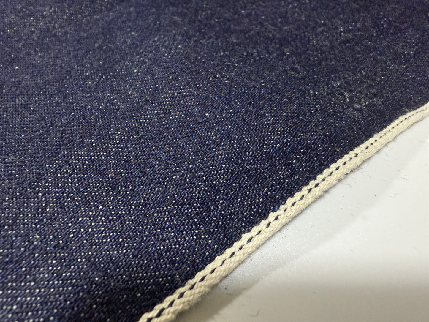 Okayama Denim 13 oz Japanese Indigo Kibata Selvage Denim fabric showing the raw edge and weave.