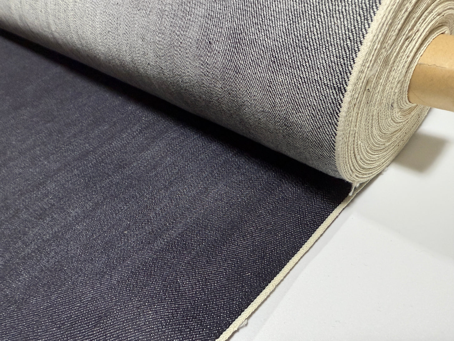 Okayama Denim roll showcasing 12.5 oz indigo Japanese selvage denim fabric by yard for versatile apparel projects.