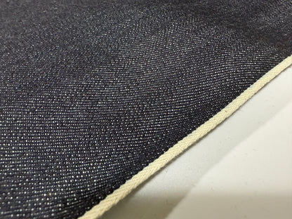 Close-up of Okayama Denim | 12.5 oz Indigo Japanese selvedge denim fabric showcasing texture and white selvage edge.