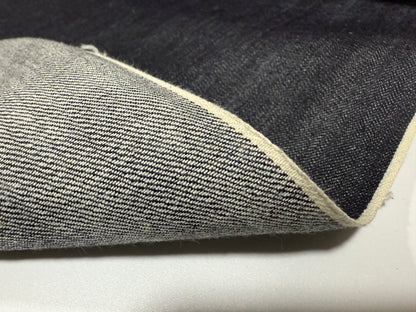 Okayama Denim showing 12.5 oz indigo Japanese selvage denim fabric with white selvage detail.