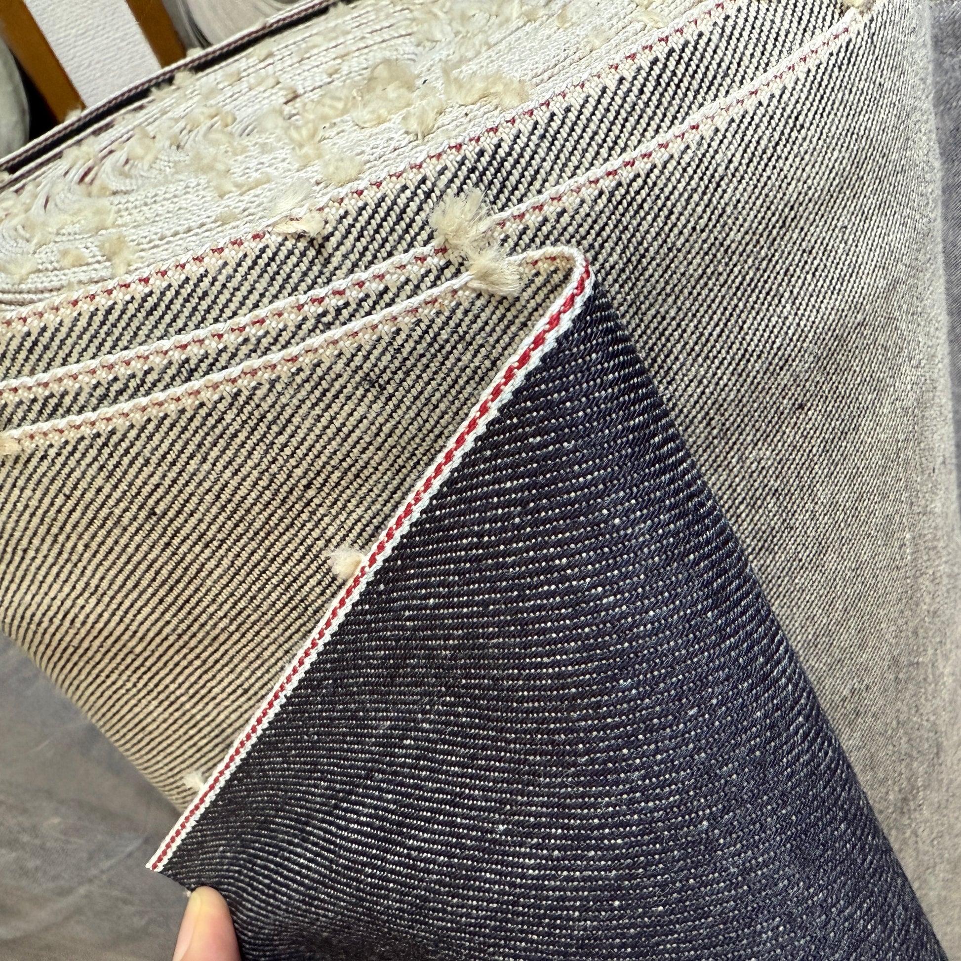 Close-up of Okayama Denim roll showcasing 19 oz Japanese heavy ounce indigo selvage denim and red selvage edges.