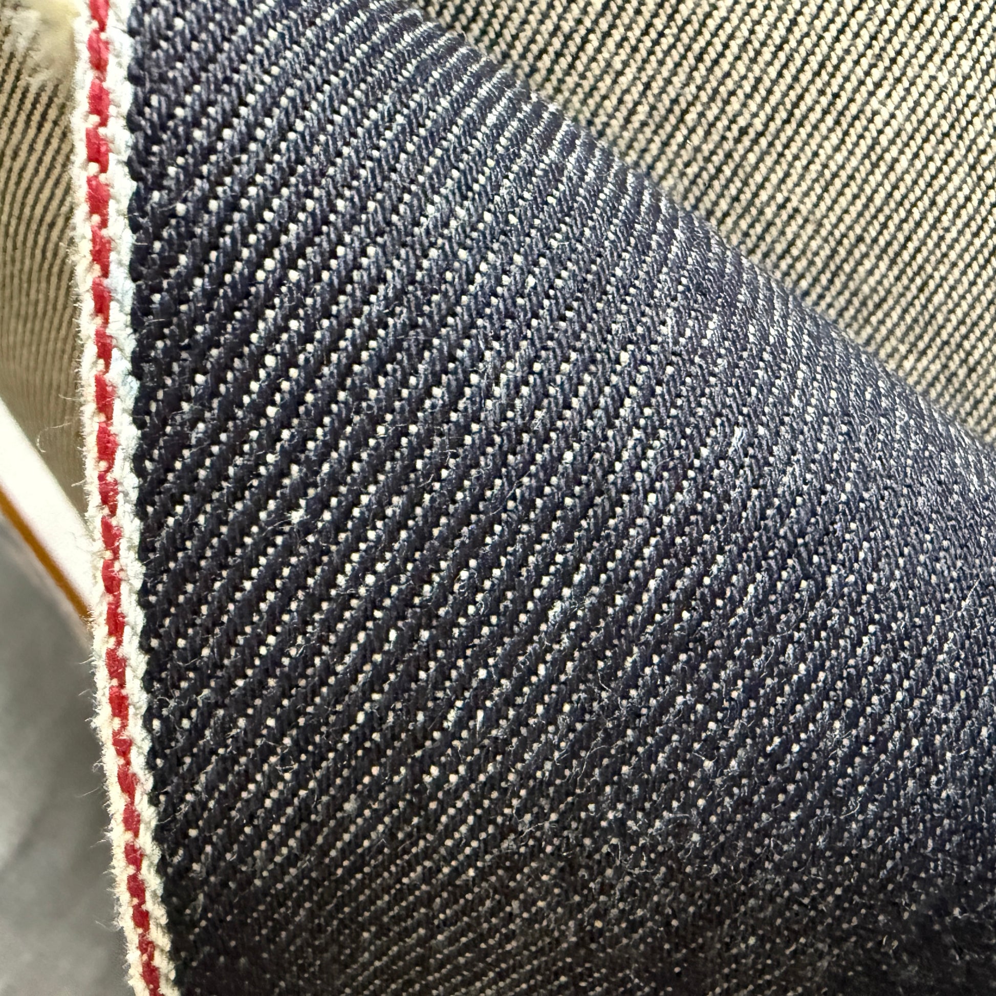 Close-up of Okayama Denim, 19 oz Japanese Heavy Ounce Indigo Selvage denim showcasing its rich texture and selvage edge.