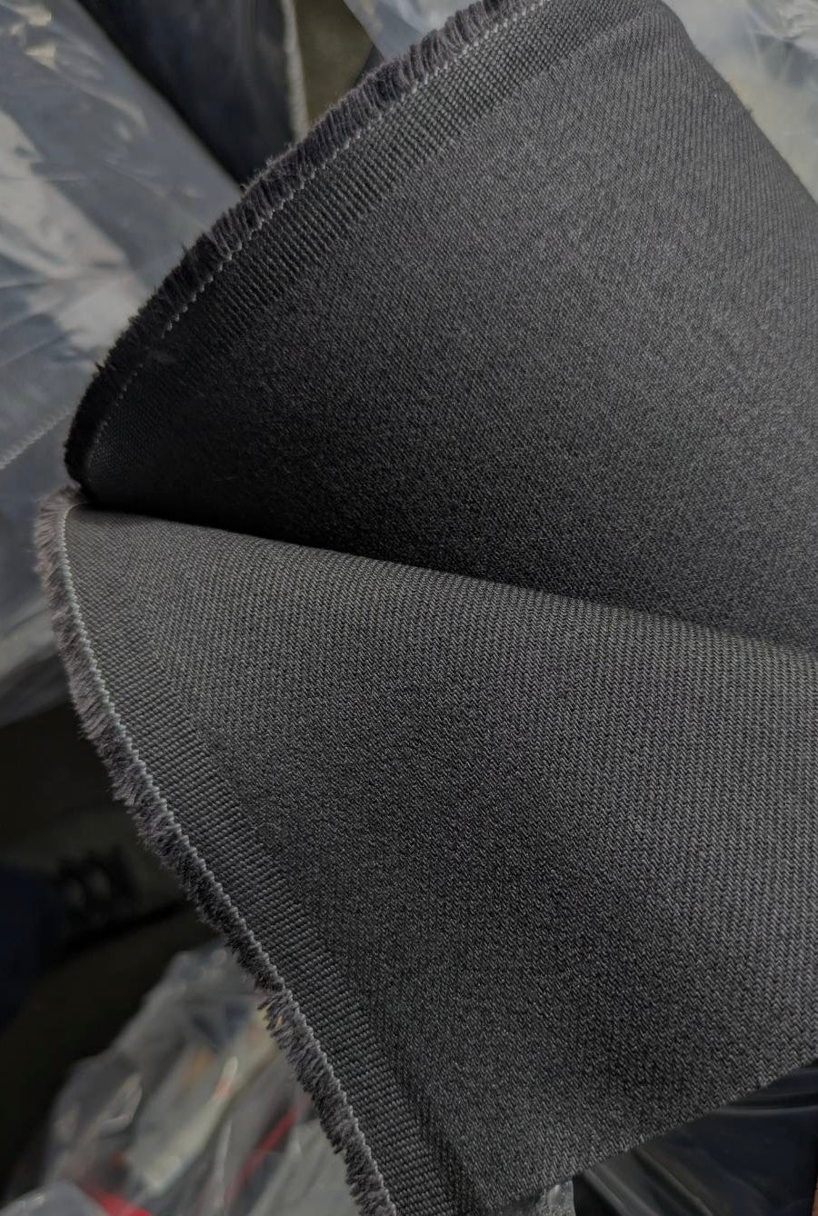 Close-up of Okayama Denim | 13.3oz double-width, double-sided black denim fabric showcasing its beautiful twill texture.