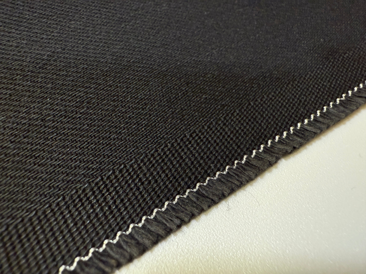 Okayama Denim | Close-up of 13.3oz double-width, double-sided black denim fabric with twill texture.