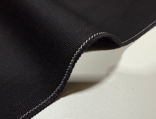 Okayama Denim | 13.3oz double width double-sided black denim fabric with a twill texture and contrasting stitching.