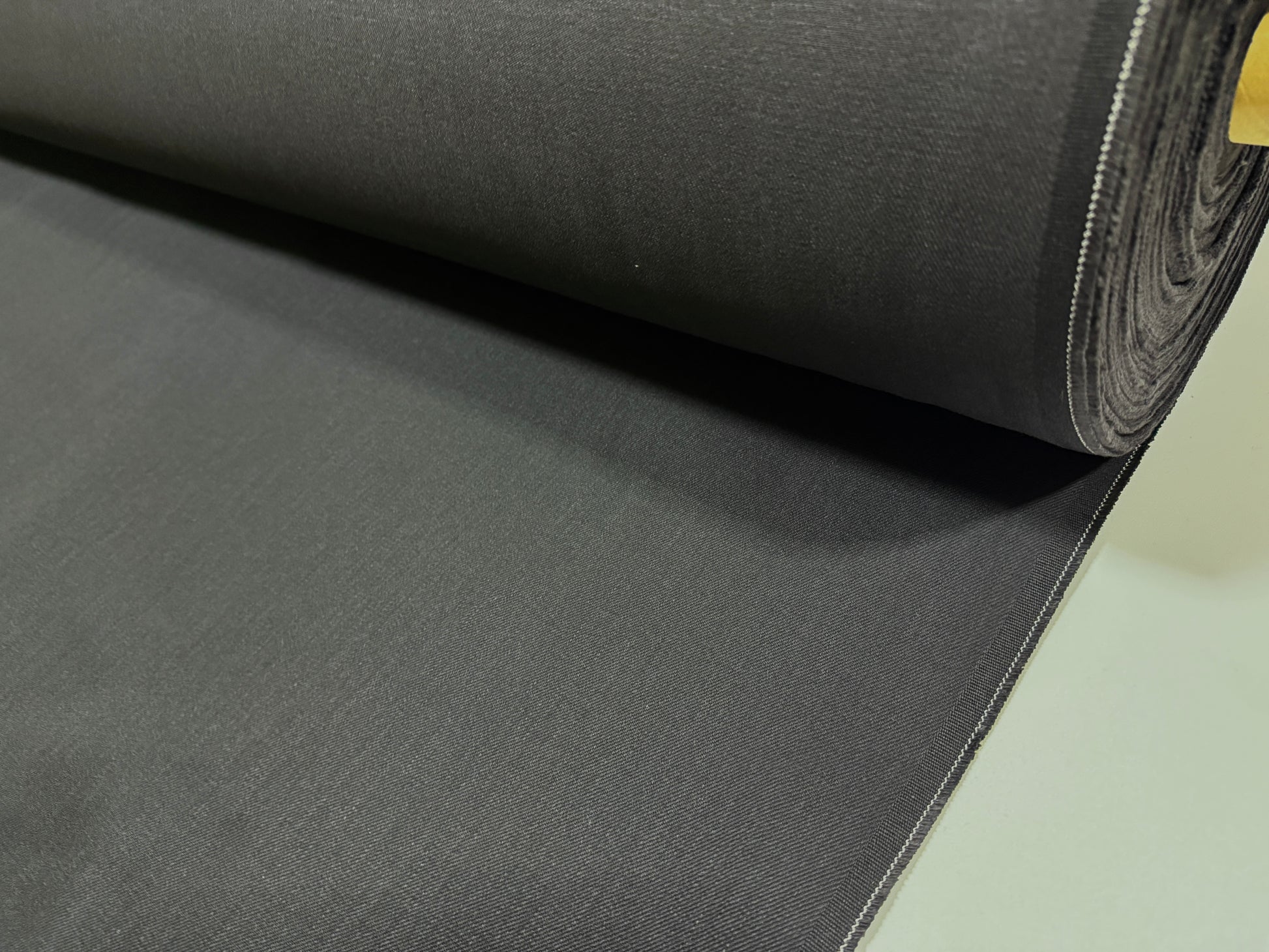 Okayama Denim | 13.3oz Double Width Double-Sided Black denim fabric roll showcasing its smooth texture and dark color.