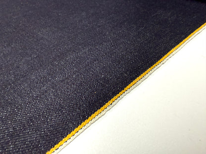 Okayama Denim | Close-up of 13 oz indigo kibata Japanese selvage denim fabric with yellow selvage detailing.