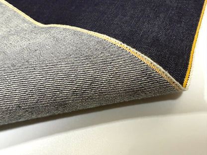 Close-up of Okayama Denim featuring 13 oz indigo kibata Japanese selvage fabric with yellow selvage edge.
