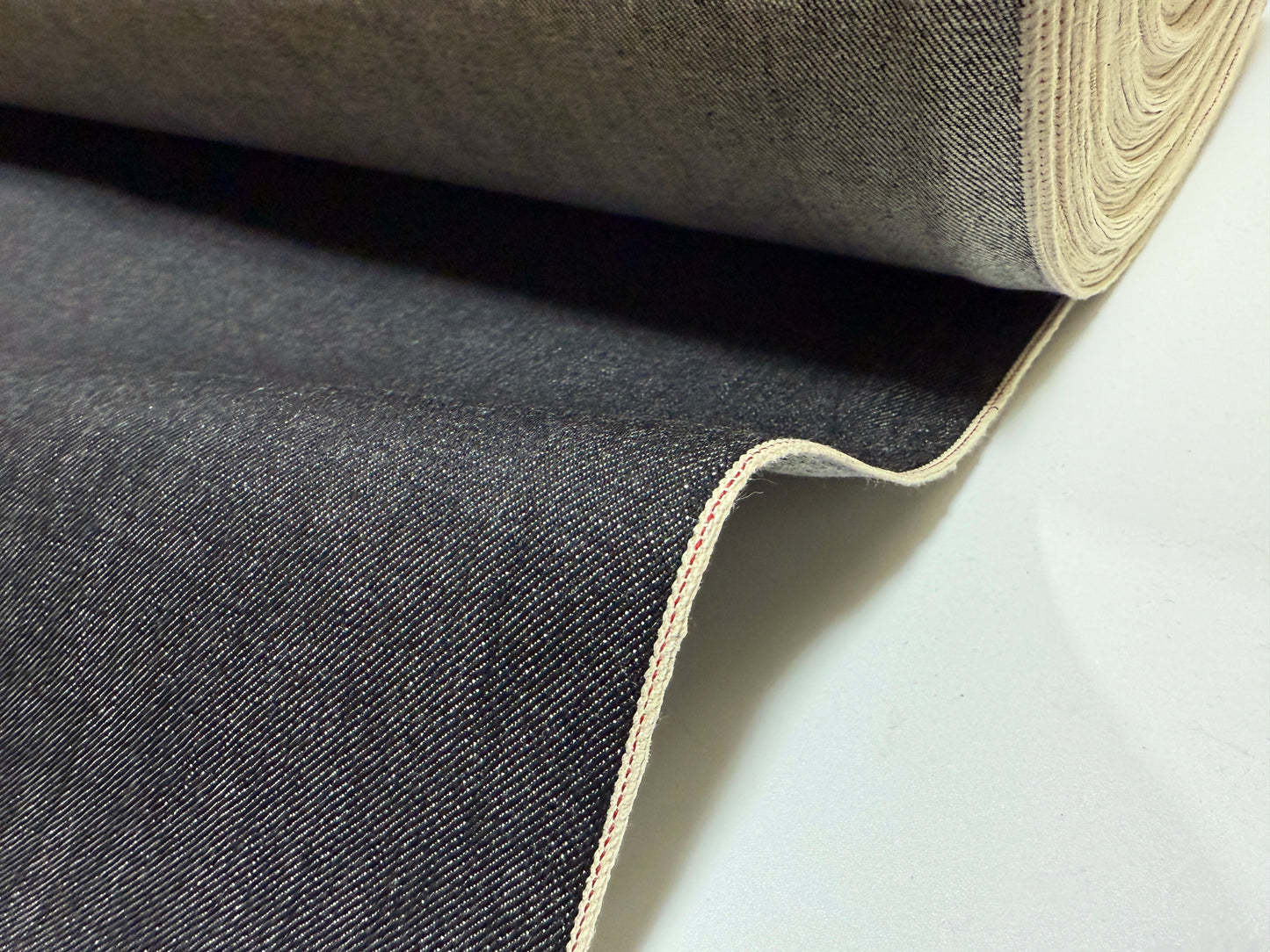 Okayama Denim roll showcasing 16.5 oz Japanese heavy ounce indigo selvage denim fabric with distinct selvage edge.