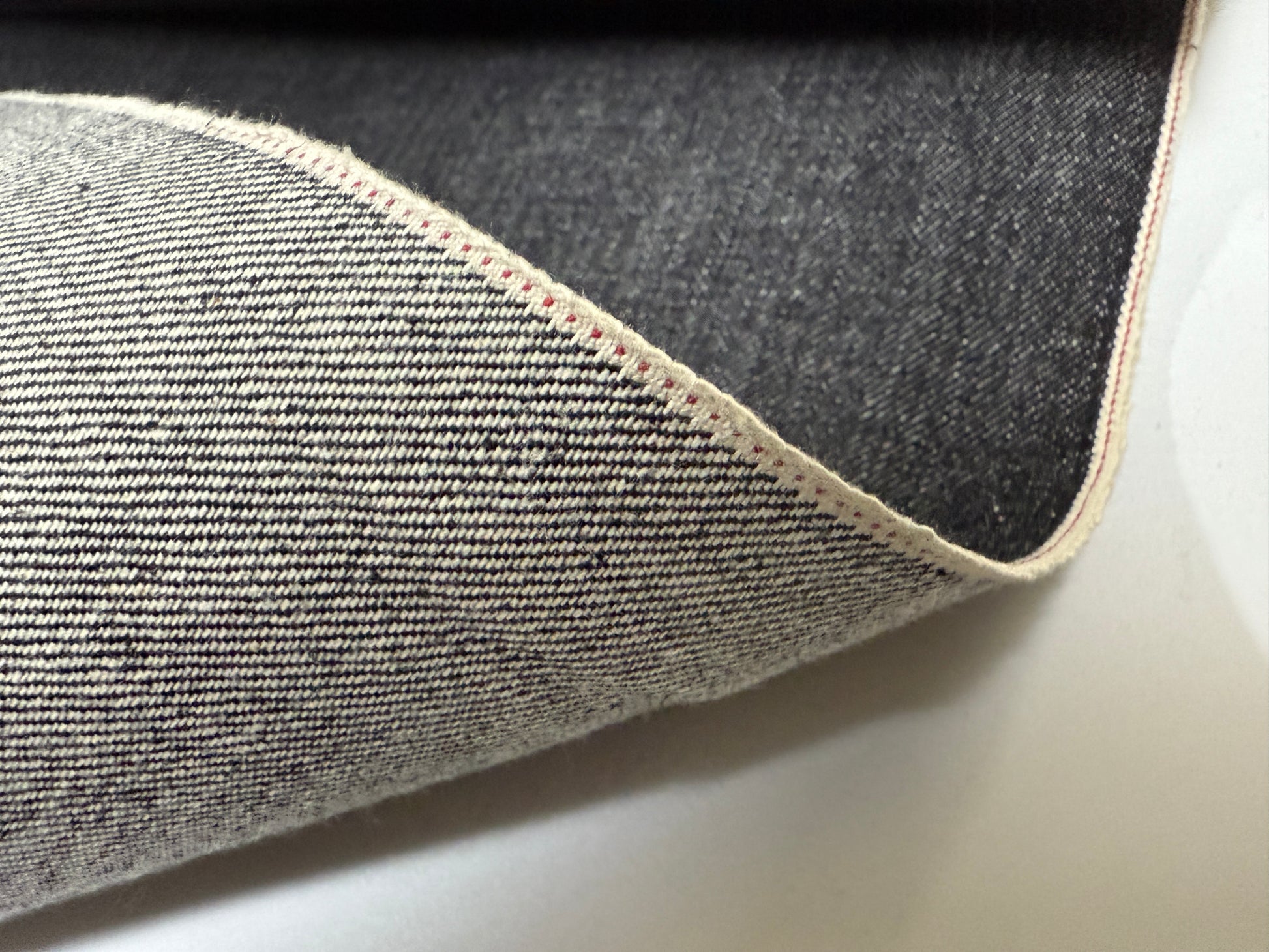 Okayama Denim folded selvage fabric showcasing rich indigo and unique texture, ideal for quality garments.