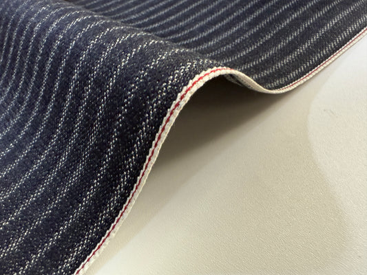 Close-up of Okayama Denim 11.3 oz Black Selvedge Hickory fabric showcasing fine stripes and selvedge details.