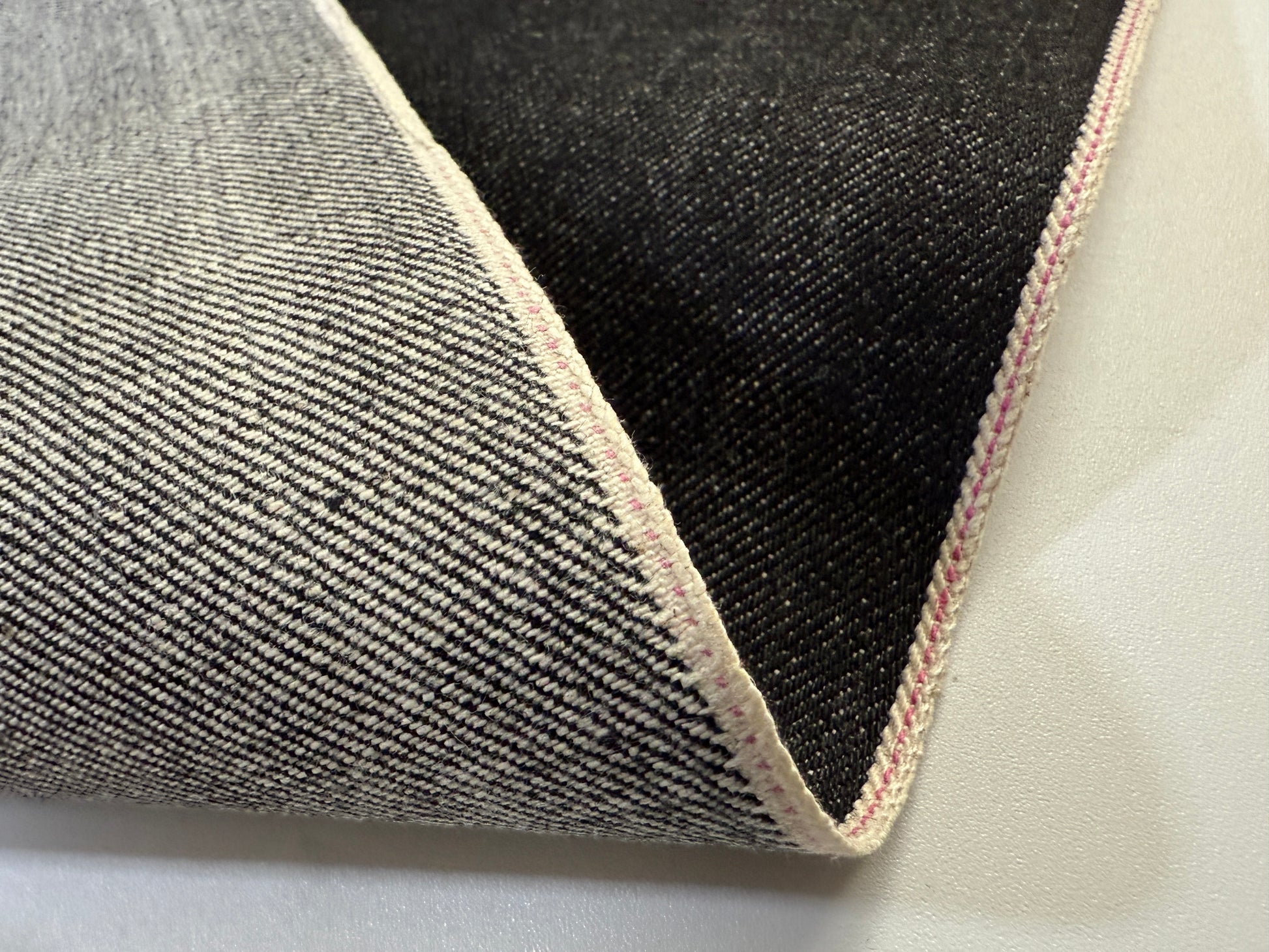 Okayama Denim 14.6oz black selvage fabric showcasing smooth texture and durability.