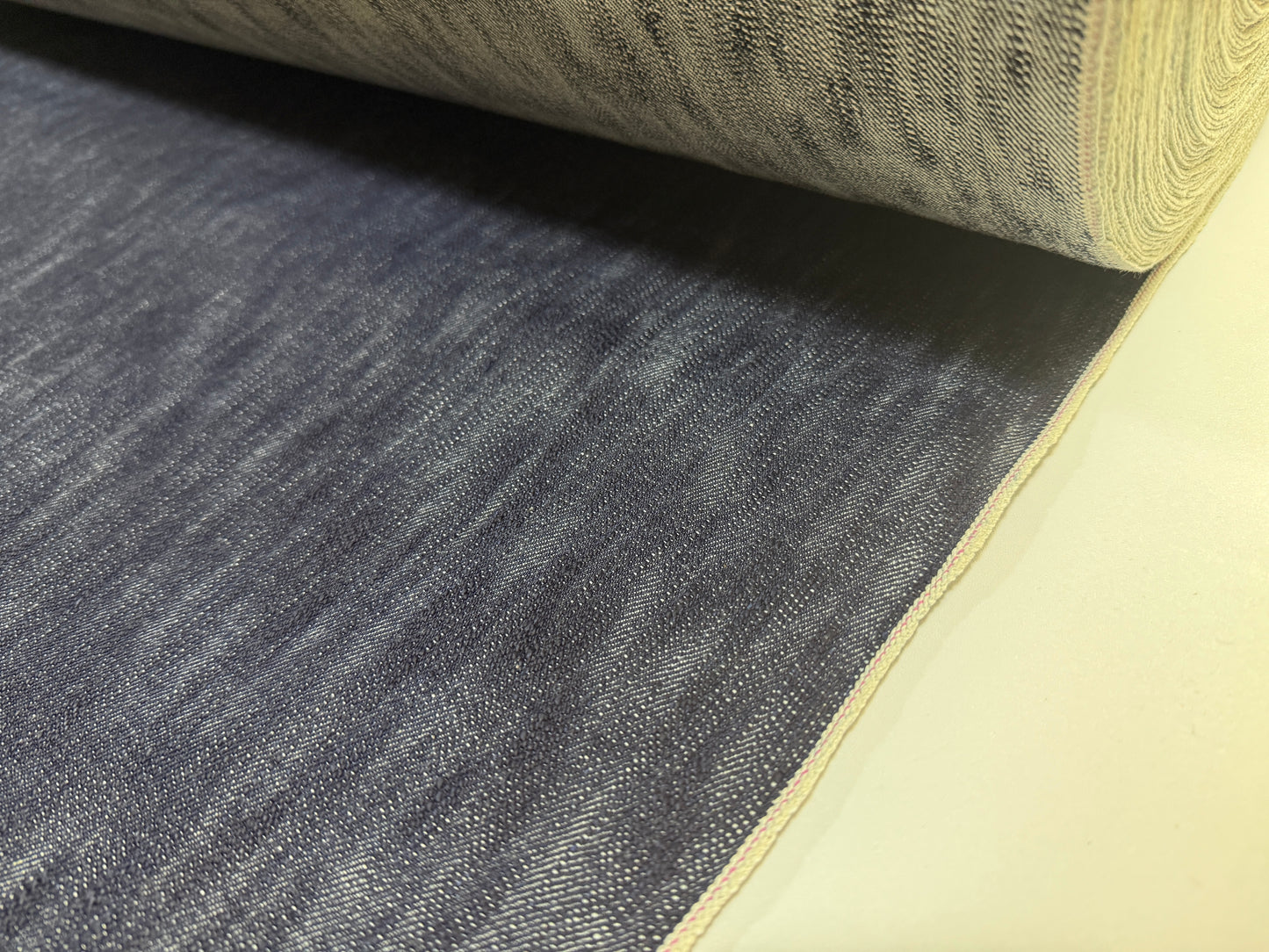 Okayama Denim 16.5oz Japanese Indigo uneven dyed slab selvage denim fabric with textured surface.