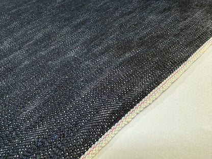 Okayama Denim 16.5oz Japanese Indigo uneven dyed slab selvage denim fabric close-up showing texture and selvage edge.