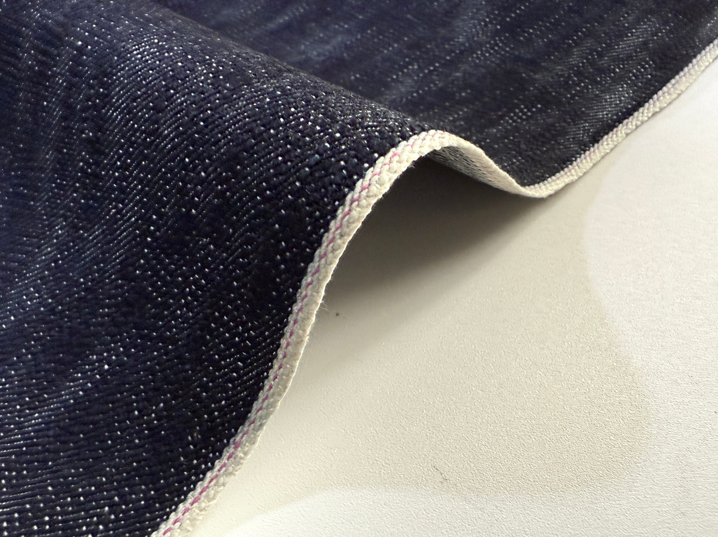 Okayama Denim in 16.5 oz Japanese Indigo Uneven Dyed Slab Selvage fabric showcasing its textured surface.
