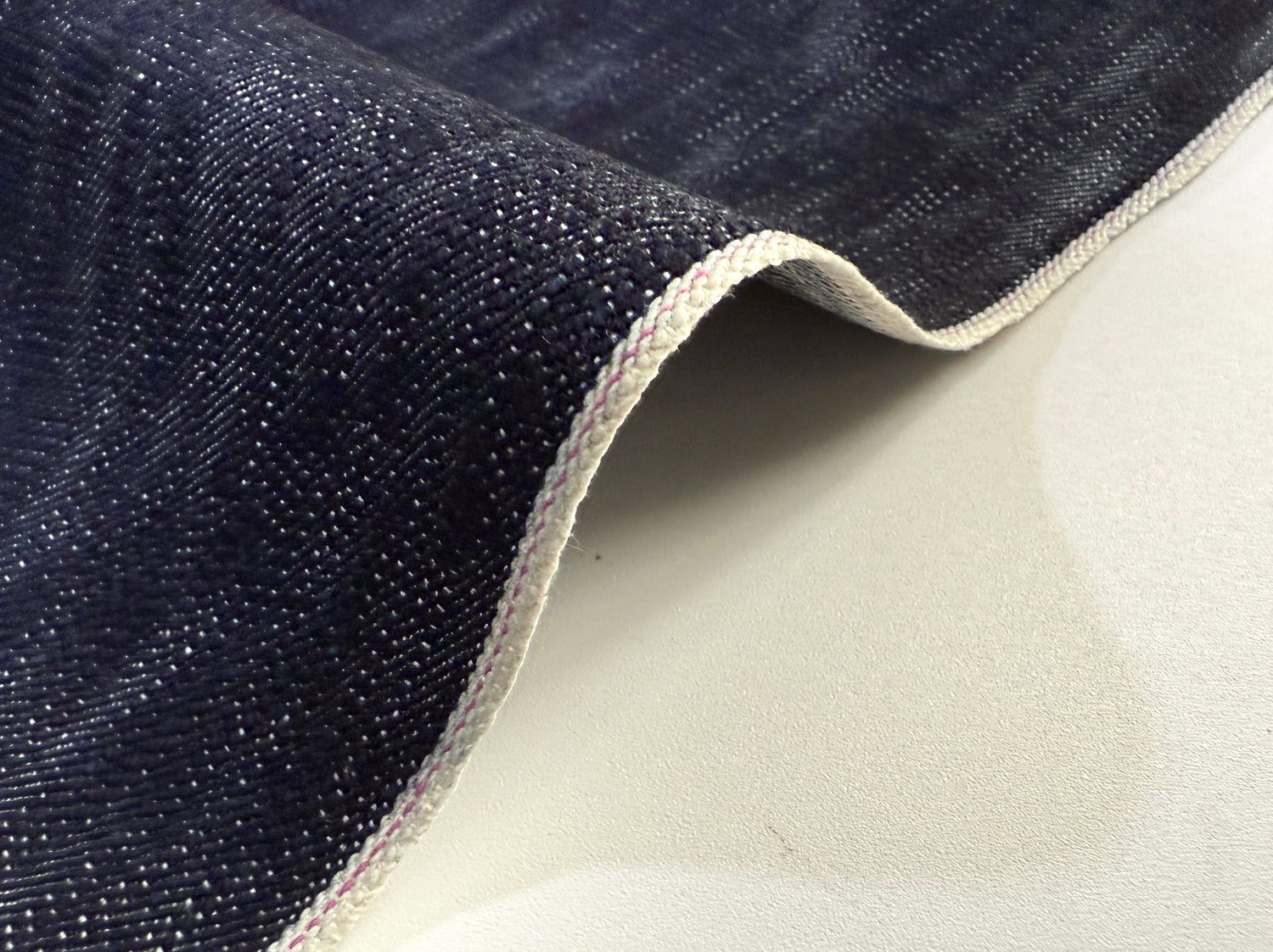 Okayama Denim in 16.5 oz Japanese Indigo Uneven Dyed Slab Selvage fabric showcasing its textured surface.