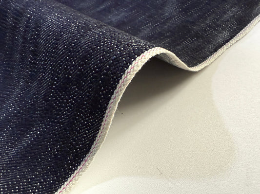 Okayama Denim in 16.5 oz Japanese Indigo Uneven Dyed Slab Selvage fabric showcasing its textured surface.