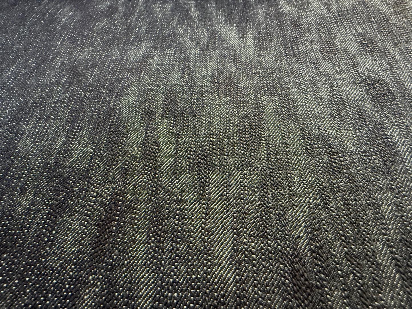 Close-up view of Okayama Denim, showcasing the unique texture of the 16.5oz Japanese indigo uneven dyed slab selvage denim.