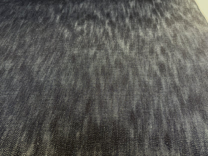Okayama Denim fabric close-up showing the unevenly dyed texture of 16.5oz Japanese indigo slab selvage denim.