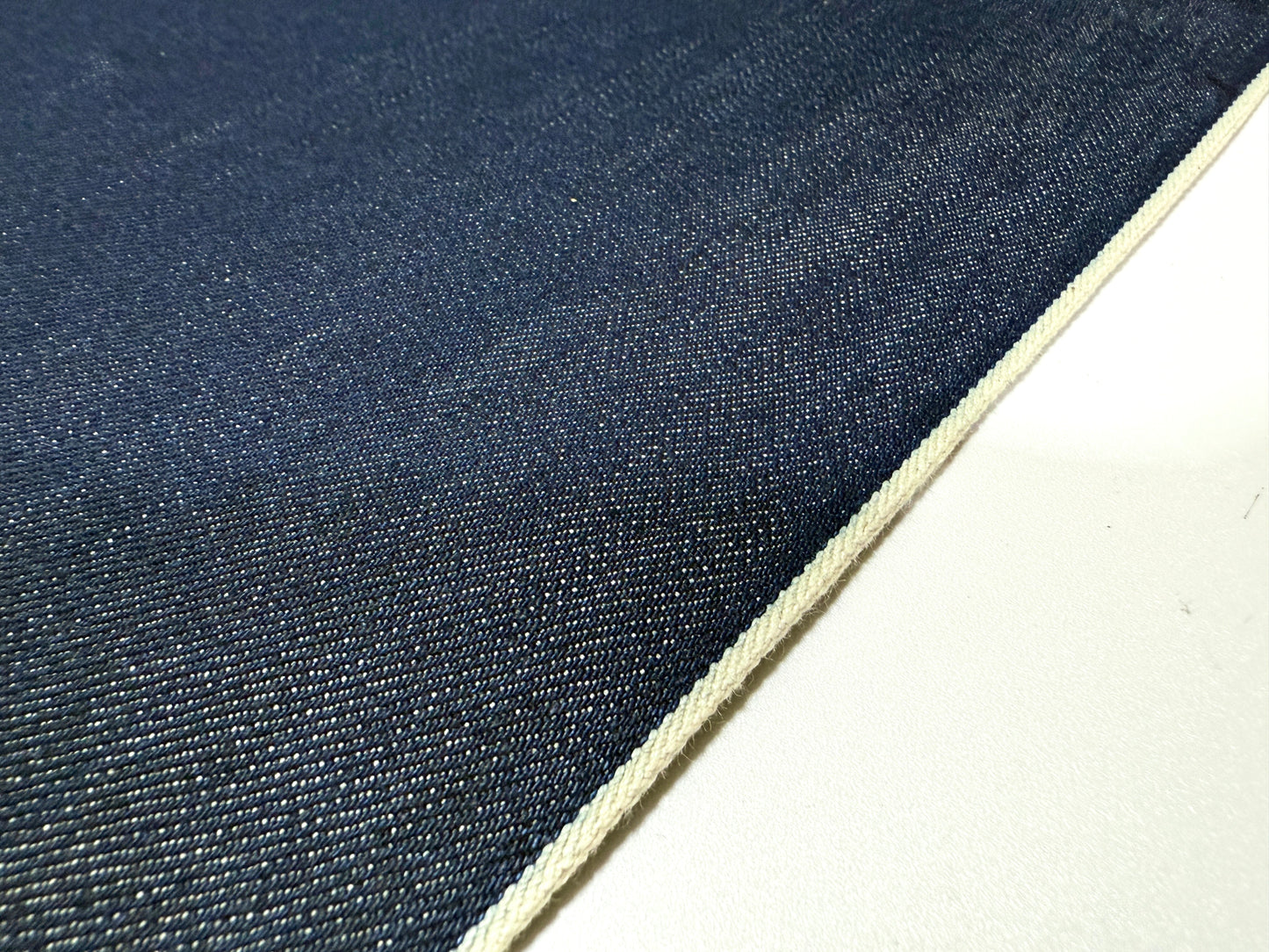 Okayama Denim | 15oz indigo selvage Japanese blue fabric showcasing smooth texture and white selvage edge.