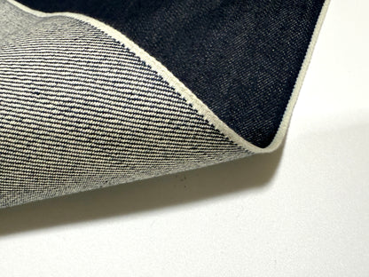 Okayama Denim | 15oz indigo selvage fabric showing smooth texture and blue selvage edges.