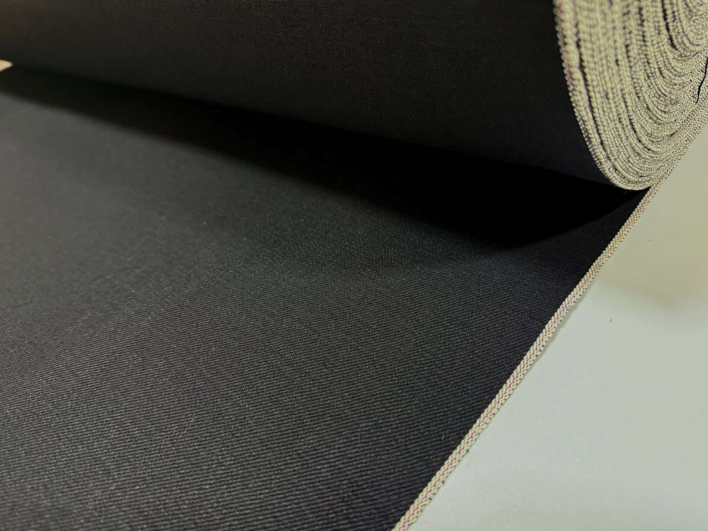 Okayama Denim | 14.6oz double-sided black Japanese selvage fabric showing smooth texture and quality craftsmanship.