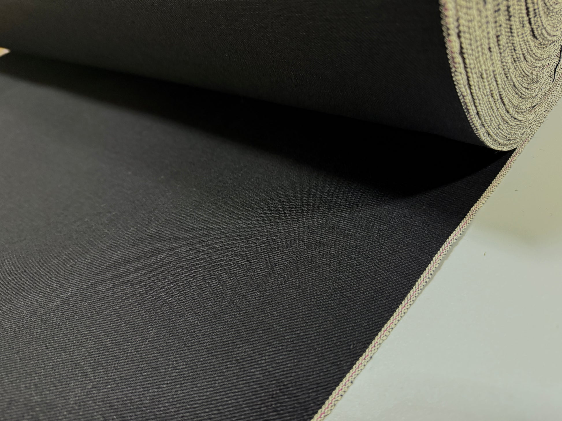 Okayama Denim | 14.6oz double-sided black Japanese selvage fabric showing smooth texture and quality craftsmanship.