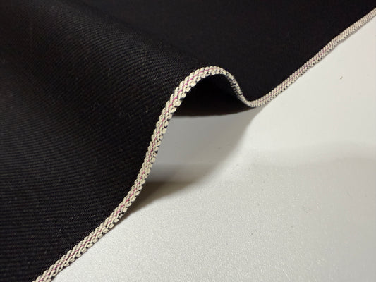 Okayama Denim | 14.6oz double-sided black Japanese selvage fabric with smooth texture and signature edge.