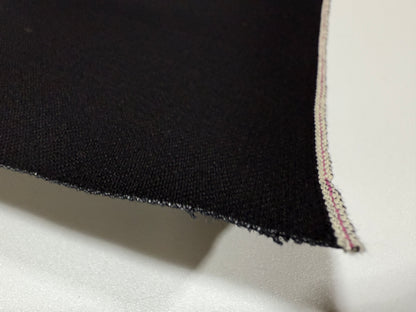 Okayama Denim | Close-up of 14.6 oz double-sided black Japanese selvage fabric showing smooth texture and edge detail.