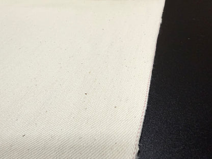 Close-up of Okayama Denim 13 oz ecru selvage fabric showcasing its soft texture and quality craftsmanship.