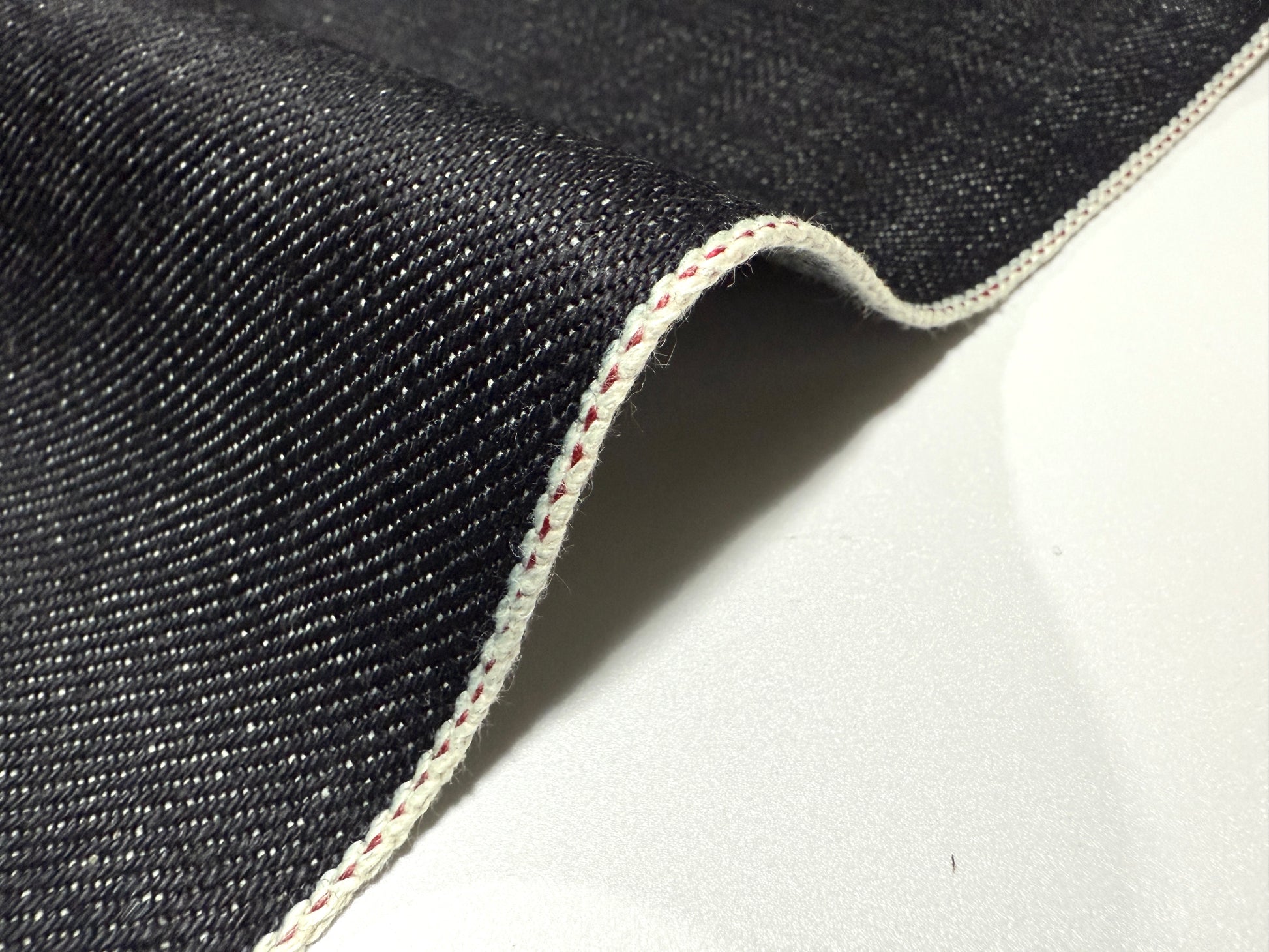 Okayama Denim 20 oz Japanese heavy ounce indigo selvage denim showcasing vivid texture and signature red selvedge stitching.