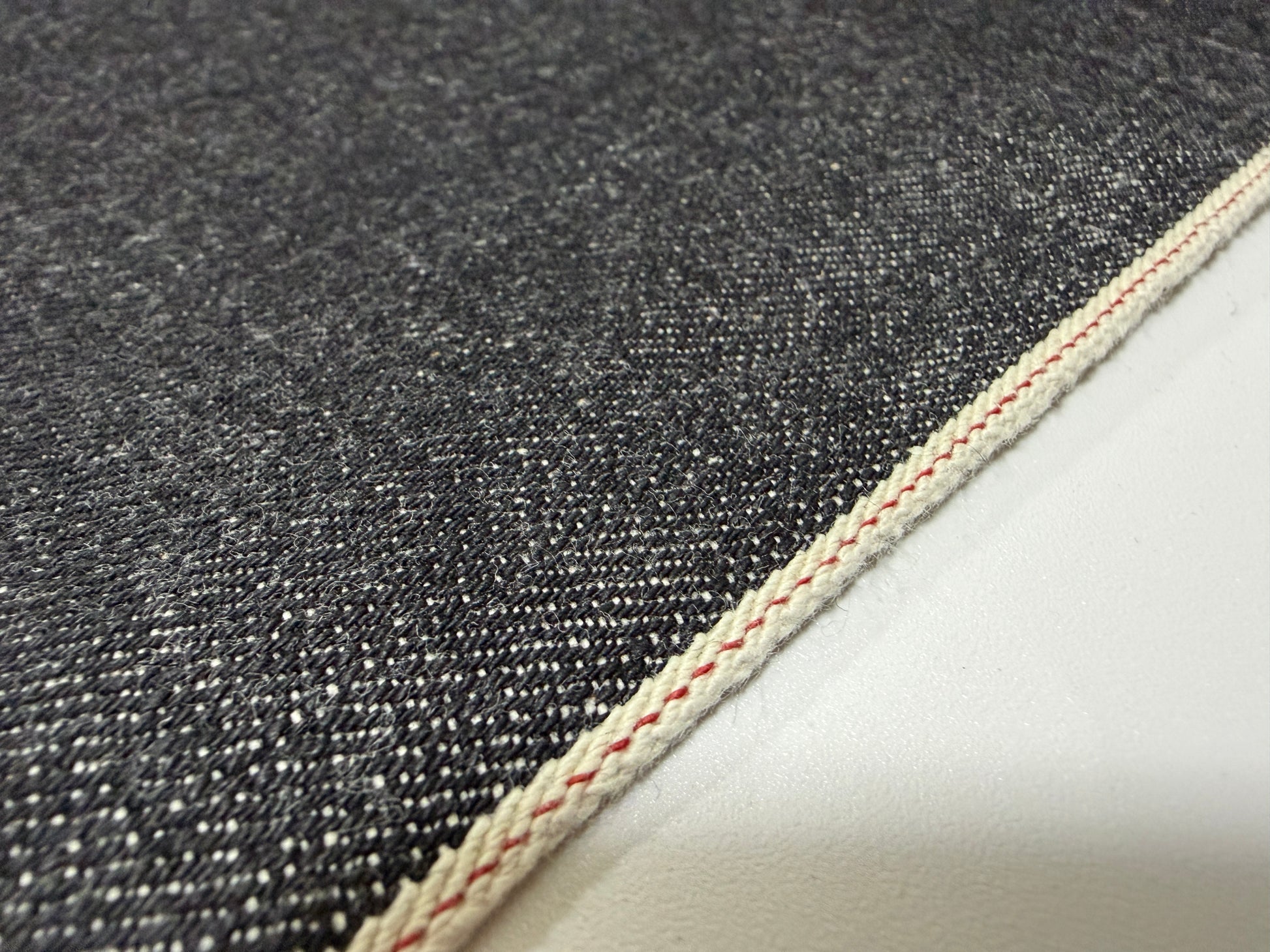 Okayama Denim 14.5 oz Black Selvage Japanese Denim showing detail of fabric and selvedge edge.