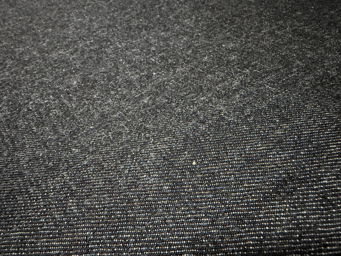 Close-up of Okayama Denim 14.5oz Japanese cotton black selvage denim fabric showcasing texture and quality.