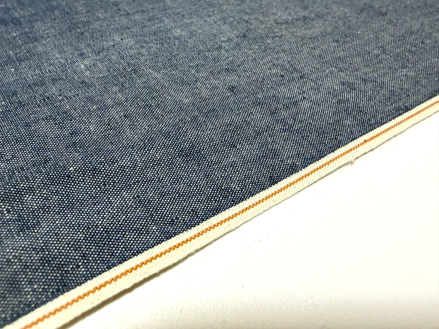 Okayama Denim 4.5 oz Japanese indigo selvage chambray fabric close-up with a crisp edge.