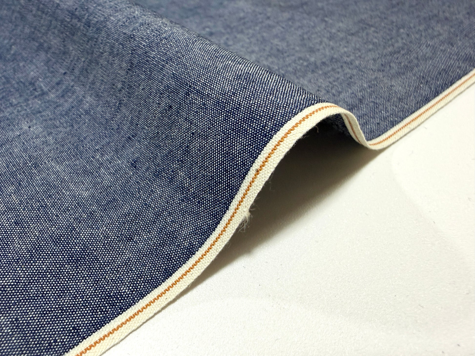 Okayama Denim 4.5 oz Japanese indigo selvage chambray fabric with crisp texture and distinctive selvage edge.