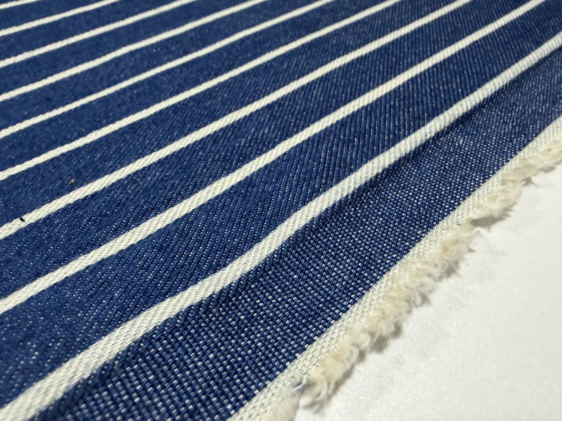 Okayama Denim fabric with blue and white stripes, showcasing Japanese cotton discharge printing by the yard.