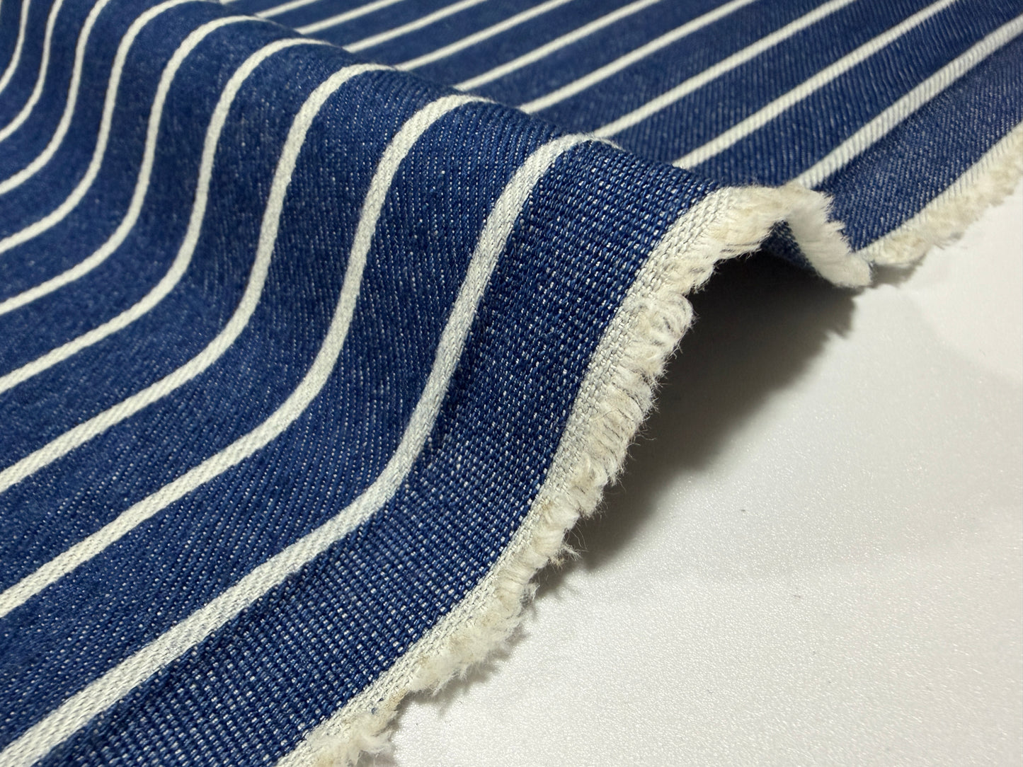 Okayama Denim fabric with Japanese indigo stripes and soft cotton texture, ideal for sewing and crafting by the yard.