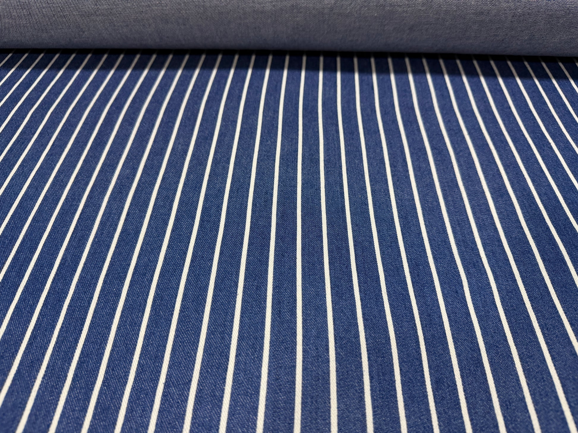 Okayama Denim fabric featuring blue and white striped pattern from Japanese indigo cotton discharge printing.
