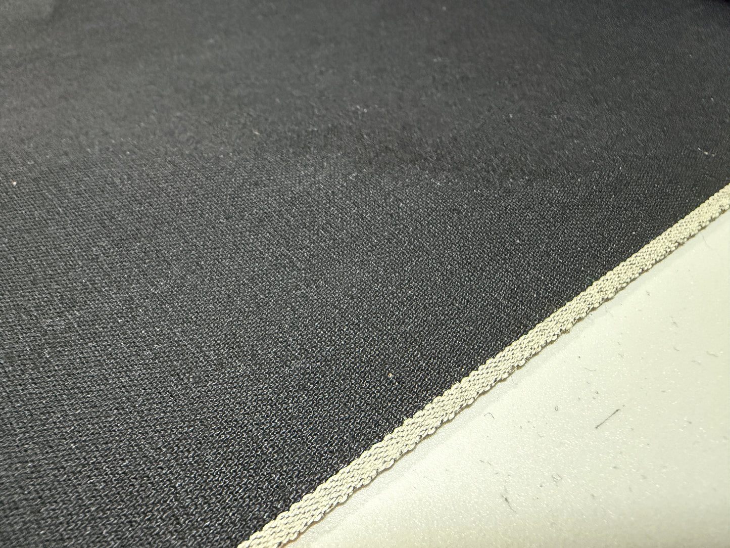 Okayama Denim 5 oz double-sided black shirt-weight fabric with a selvedge edge, showcasing its soft texture.