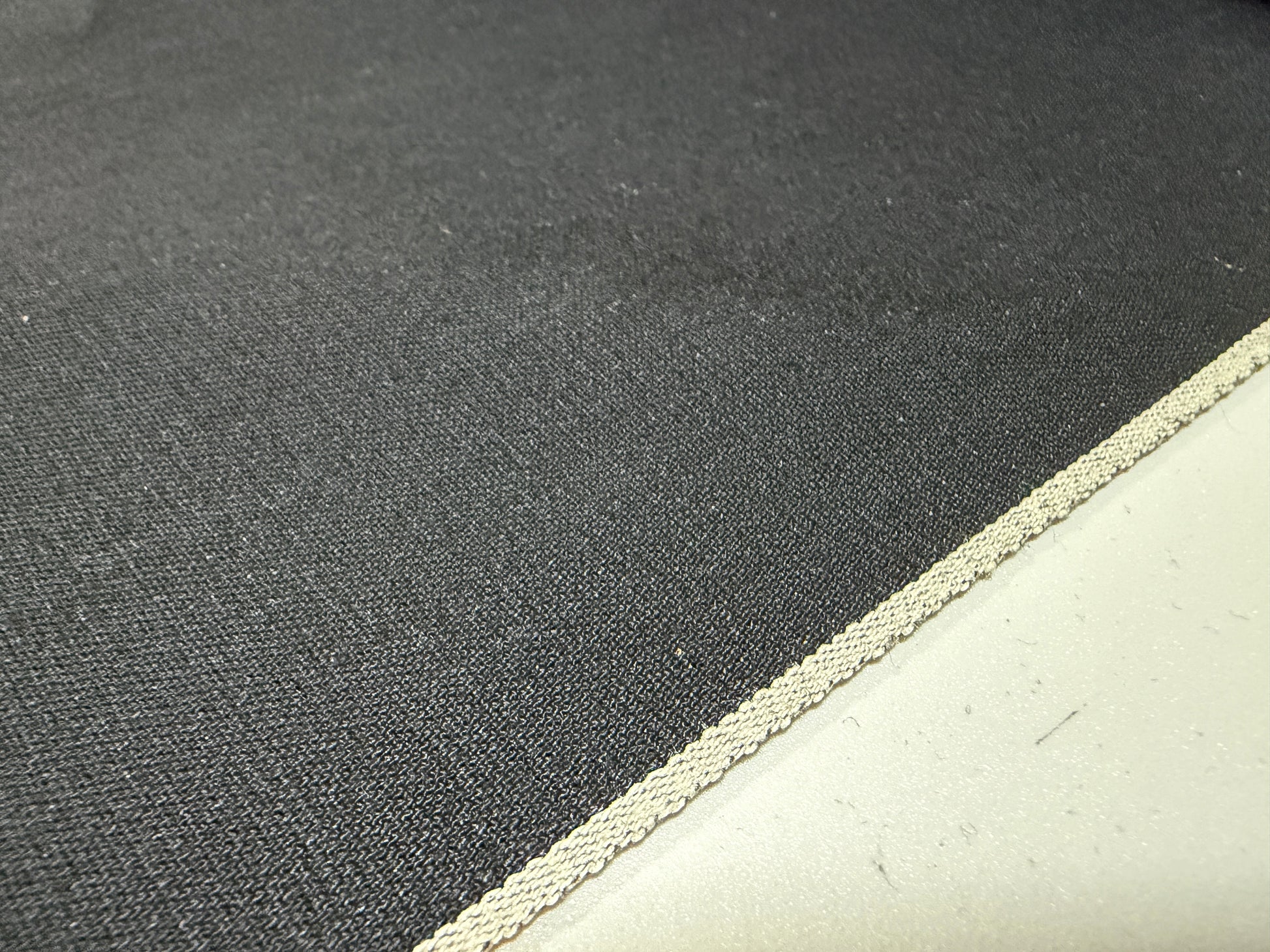 Okayama Denim 5 oz double-sided black shirt-weight fabric with a selvedge edge, showcasing its soft texture.