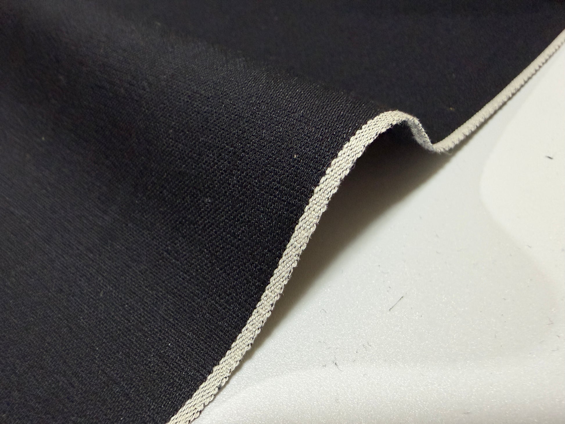 Okayama Denim black fabric with selvedge edge, suitable for shirt-making, showcasing soft texture.