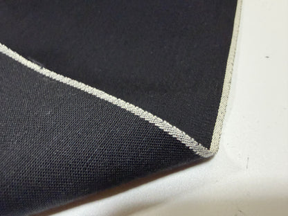 Close-up of Okayama Denim fabric showcasing the selvedge edge and soft black texture.
