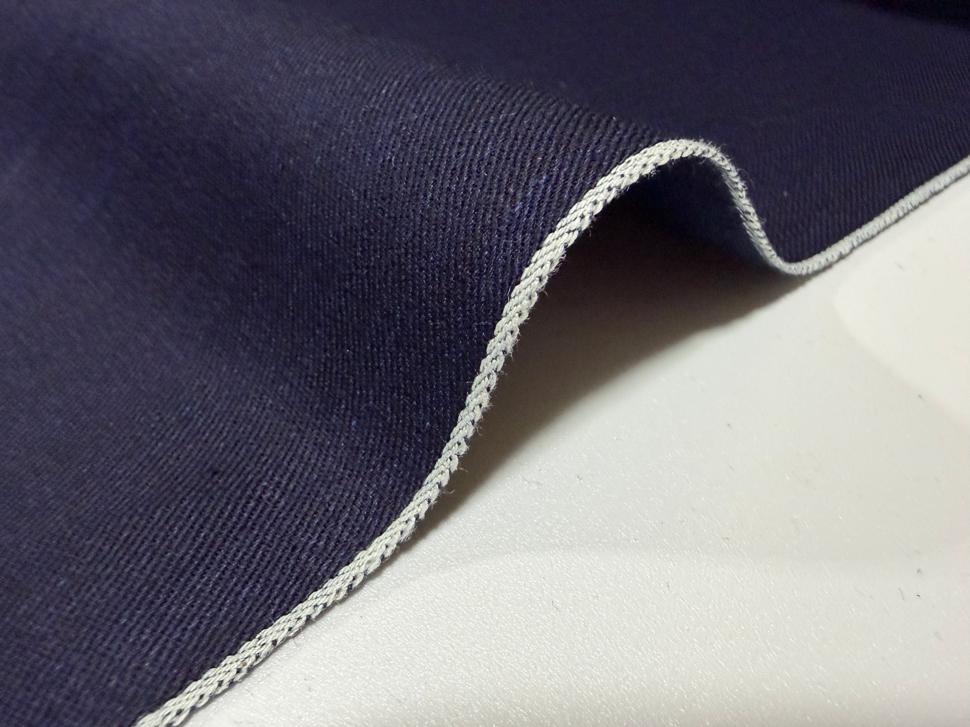 Close-up of Okayama Fabric, a 6.5 oz double-sided indigo shirt-weight fabric with a clean selvedge edge.