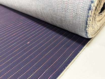 Okayama Denim 7 oz Sashiko Stripes Cotton Fabric with colorful stitching pattern rolled up on a table.