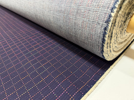Okayama Denim 7 oz Sashiko Grid Cotton Fabric featuring colorful stitching and unique pattern, rolled and ready for use.