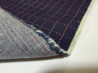 Okayama Denim 7 oz Sashiko 'Grid' cotton fabric showcasing colorful stitching and frayed edge.