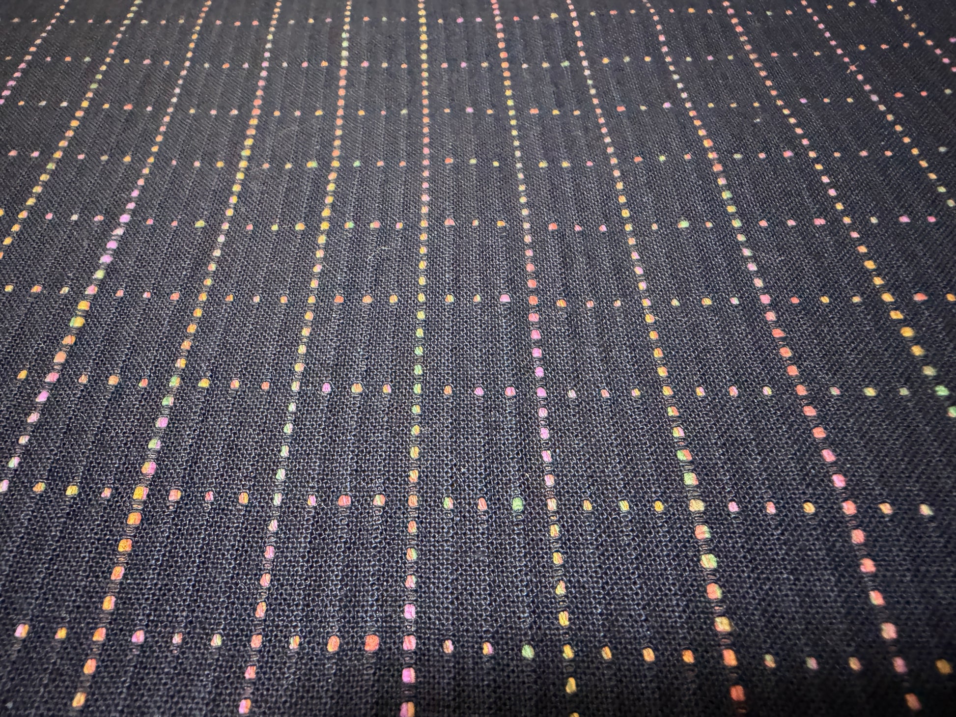 Okayama Denim 7 oz Sashiko "Grid" Cotton Fabric featuring colorful stitching on a dark background.
